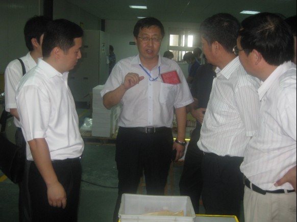 九游网站入口永磁董事长蔡报贵与金风科技董事长武钢在磁钢充磁车间交流场景.jpg